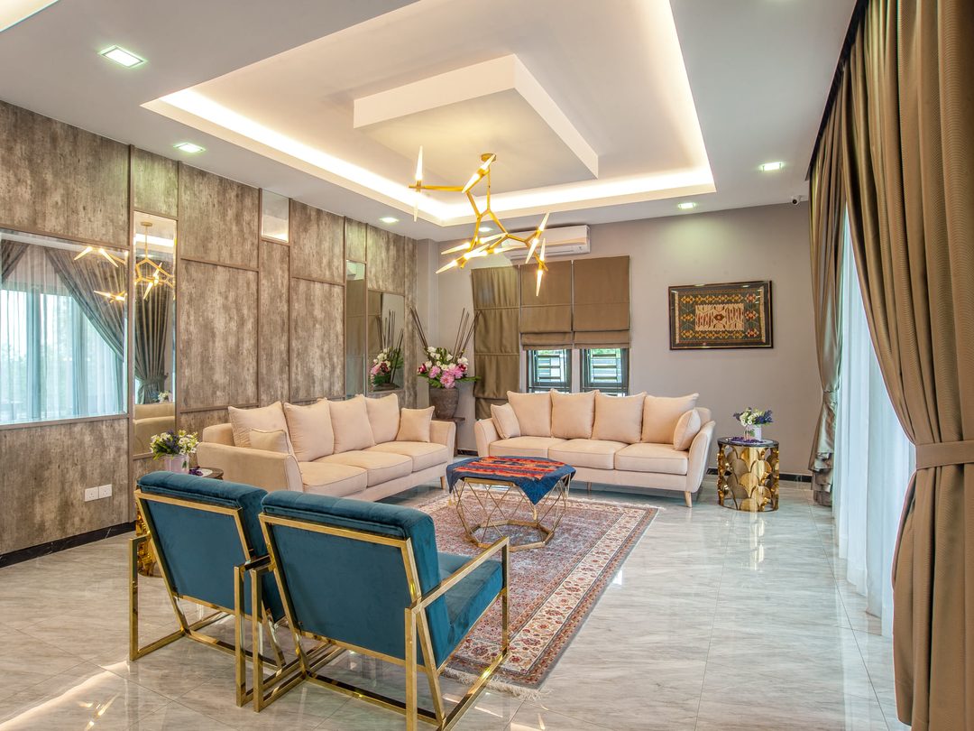 Living room with brass-framed lounge chairs and layered lighting